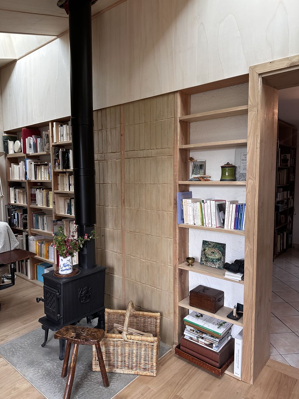 Le mur de briques encadré par les rayonnages de la bibliothèque