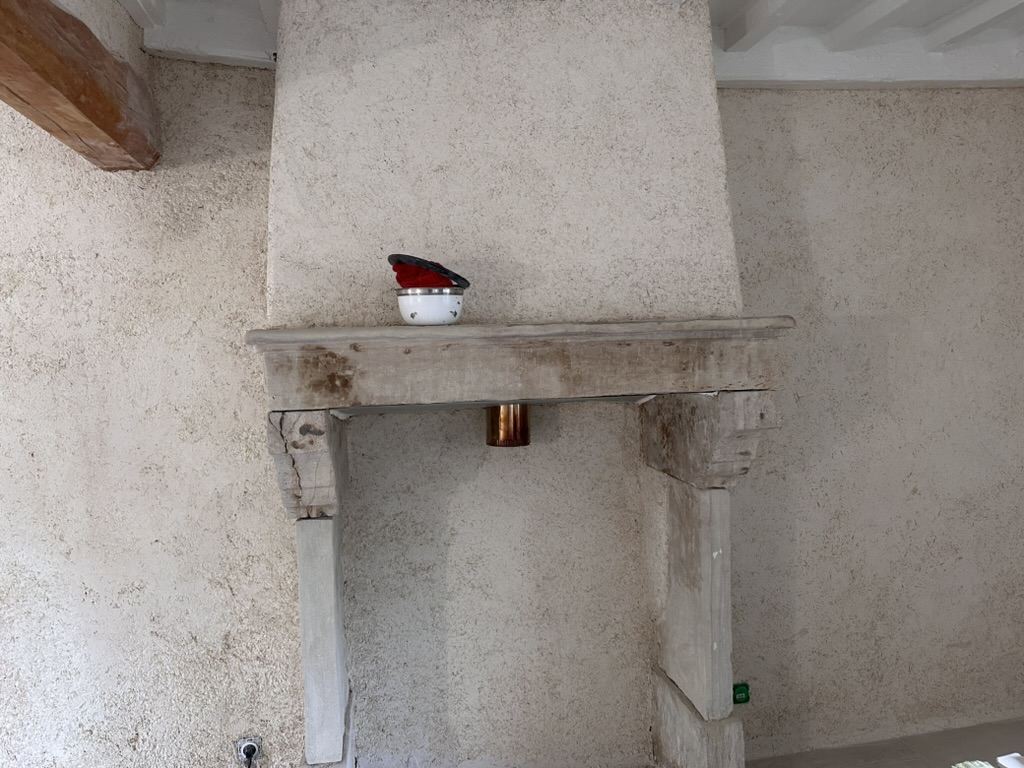Mur en chaux-chanvre autour d'une cheminée en pierre conservée