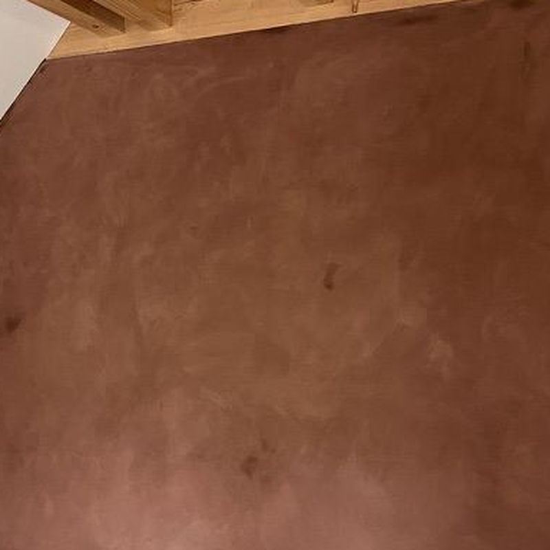 Macro d'un enduit à la chaux patiné, teinte terracotta profonde